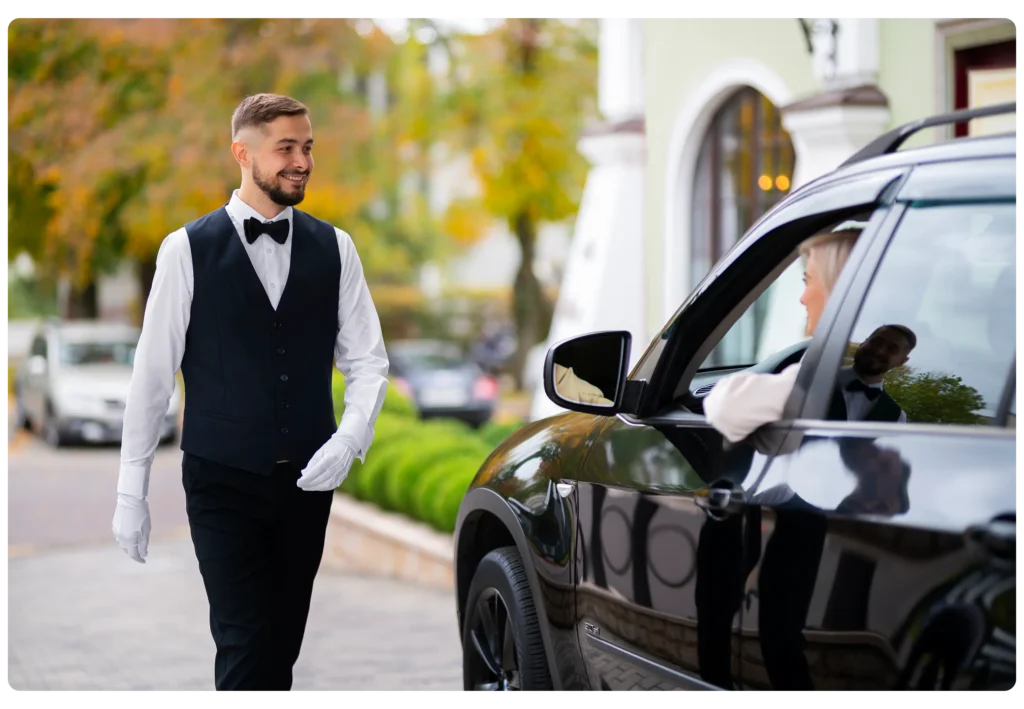 Professional chauffeur in Dubai welcoming passenger for luxury private driver service.